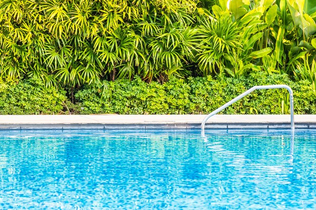 Bela piscina ao ar livre com cama espreguiçadeira e guarda-chuva no resort para viagens e férias