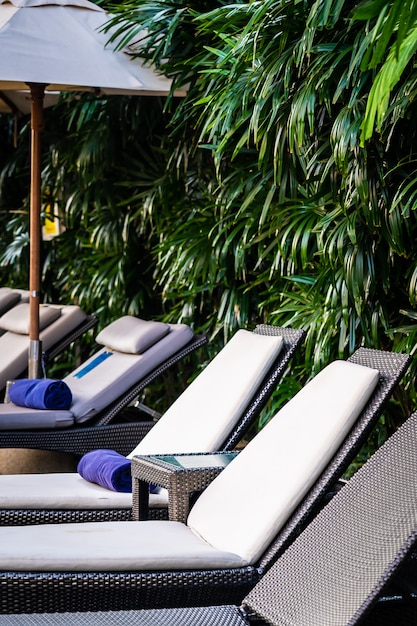 Foto grátis bela piscina ao ar livre com cama espreguiçadeira e guarda-chuva no resort para viagens e férias