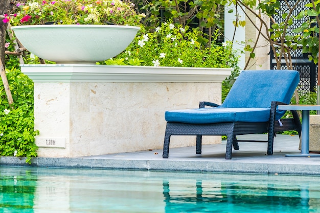 Bela piscina ao ar livre no hotel e resort com cadeira e deck para as férias de lazer