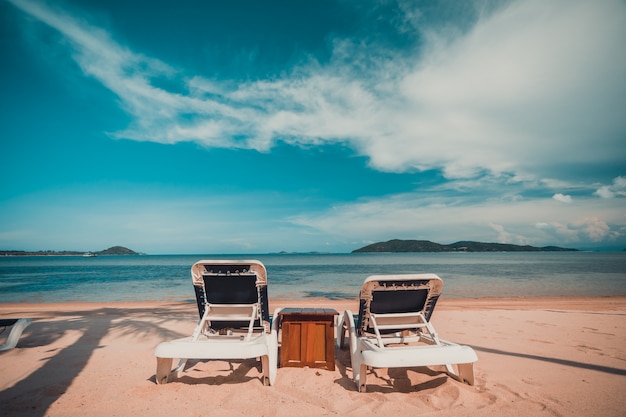 Bela praia tropical e mar com coqueiro e cadeira na ilha paradisíaca