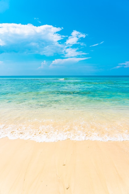 Bela praia tropical vazia, mar oceano com nuvem branca no fundo do céu azul