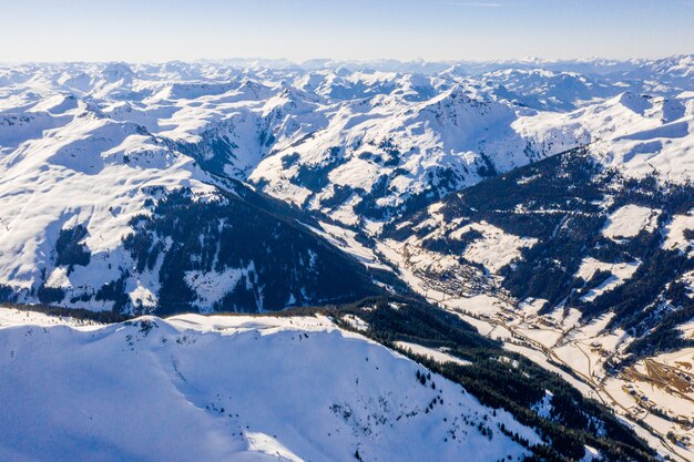 Bela vista aérea de uma estação de esqui e uma vila em uma paisagem montanhosa, nos Alpes