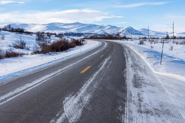 Bela vista da frozen road no meio do inverno frio na noruega