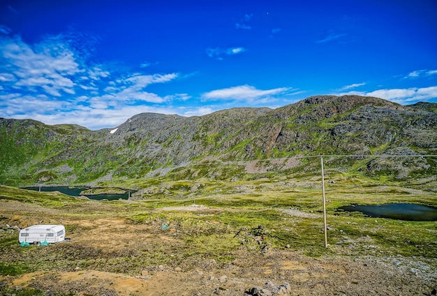 Foto grátis bela vista das montanhas e campos cobertos de grama sob o céu azul claro na suécia
