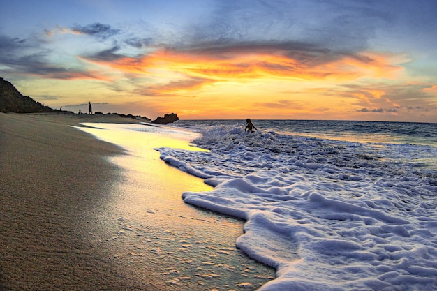 Bela vista das ondas espumosas que banham a costa arenosa