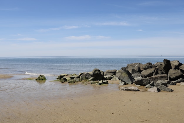 Bela vista de pedras na costa de um mar sob a luz