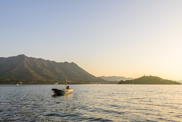 Bela vista de uma lancha na superfície calma do mar perto das montanhas