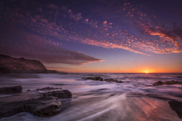 Bela vista de uma praia com momentos durante o pôr do sol