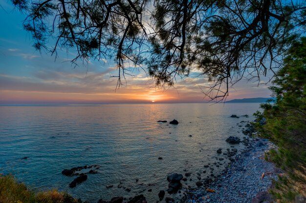 Bela vista do pôr do sol sobre o oceano calmo capturado em Lesbos, Grécia