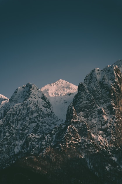 Belas montanhas rochosas altas com uma montanha de neve no meio