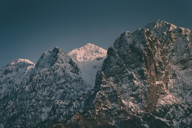 Belas montanhas rochosas altas com uma montanha de neve no meio