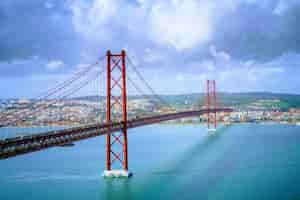 Foto grátis belas paisagens da ponte 25 de abril em portugal sob as formações de nuvens de tirar o fôlego