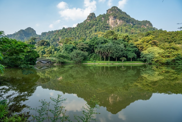 Belas paisagens de árvores verdes e altas montanhas refletidas no lago