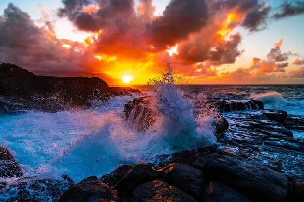 Belas paisagens de formações rochosas à beira-mar em Queens Bath, Kauai, Havaí ao pôr do sol