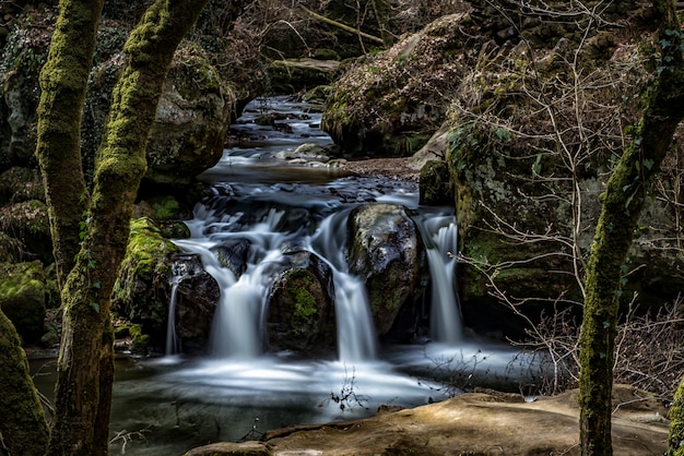 Belas paisagens de uma cachoeira na floresta cercada por formações rochosas