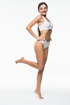 Beleza do corpo da mulher, modelo magro andando de cueca branca isolada sobre parede branca