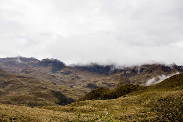 Belo campo com incríveis montanhas rochosas e colinas e céu nublado incrível