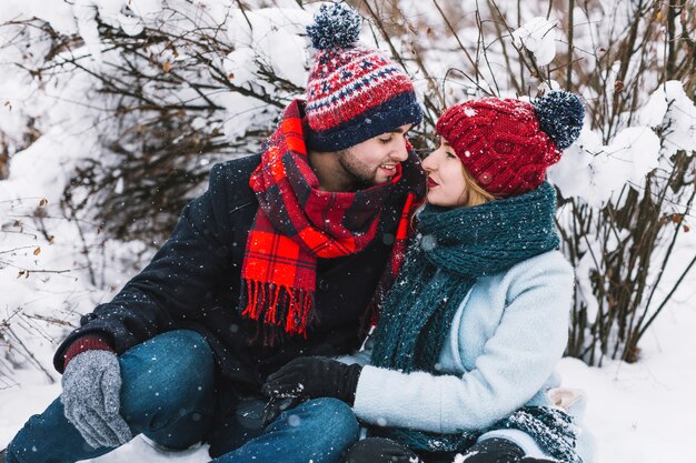 Belo casal apaixonado sentado na neve