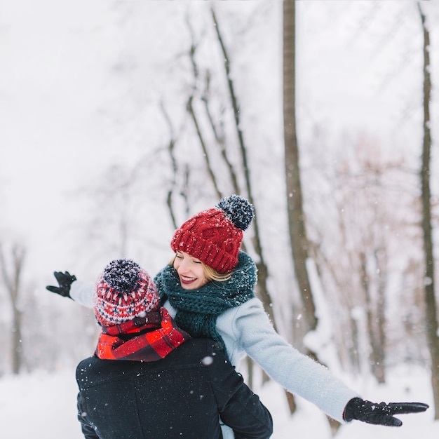 Belo casal feliz se divertindo com a queda de neve