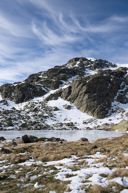 Belo cenário de uma paisagem coberta de neve com penhascos rochosos sob um céu nublado