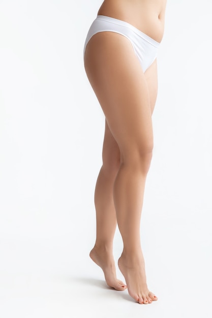 Belo corpo feminino em roupa interior isolado no branco.