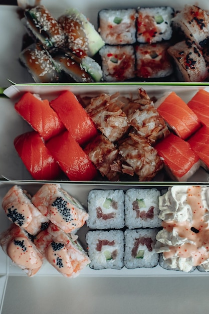 Foto grátis belo e delicioso sushi entrega de sushi rolos de sushi publicitários feitos de peixe e queijo