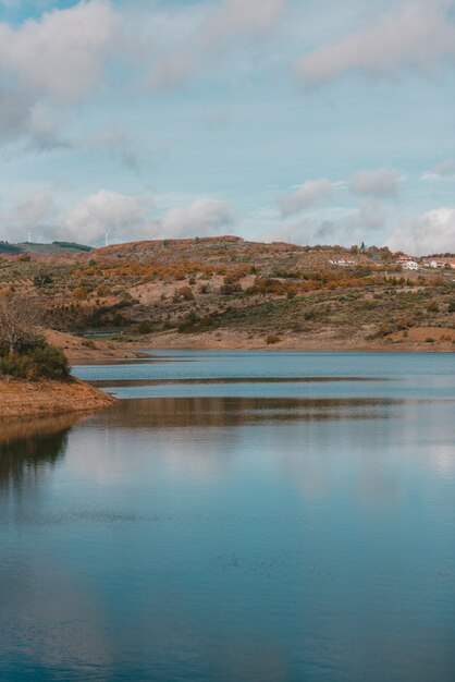 Belo lago cercado por uma cordilheira sob um céu nublado de tirar o fôlego