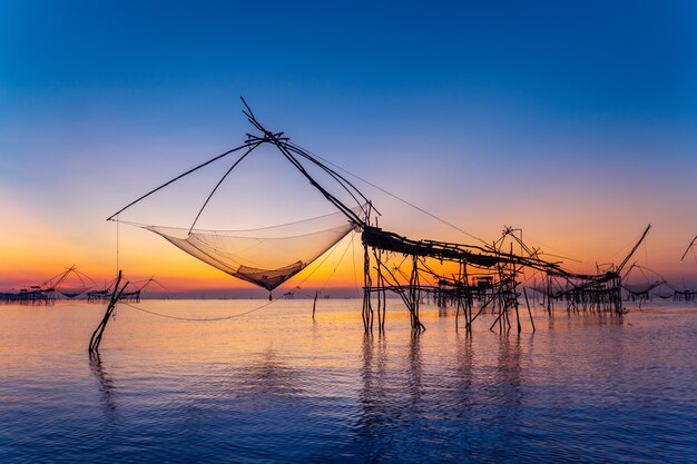 Belo nascer do sol e redes de mergulho de pesca em Pakpra em Phatthalung, Tailândia.