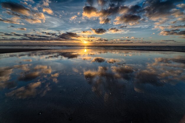 Belo nascer do sol refletindo no mar, criando o cenário perfeito para caminhadas matinais