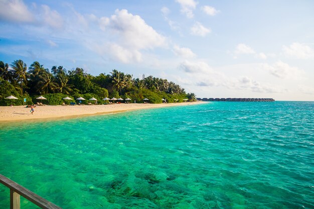 Belo oceano ondulado atingindo a praia de areia na Ilha das Maldivas