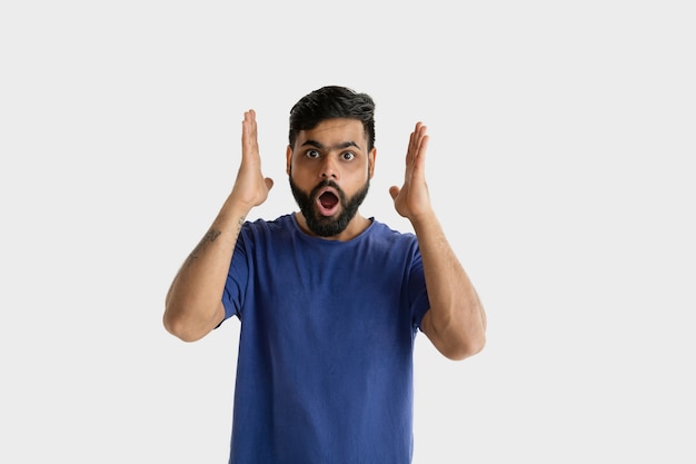 Foto grátis belo retrato de meio corpo masculino isolado na parede branca. jovem hindu emocional de camisa azul. expressão facial, emoções humanas, conceito de anúncio. atônito, chocado, louco de felicidade.