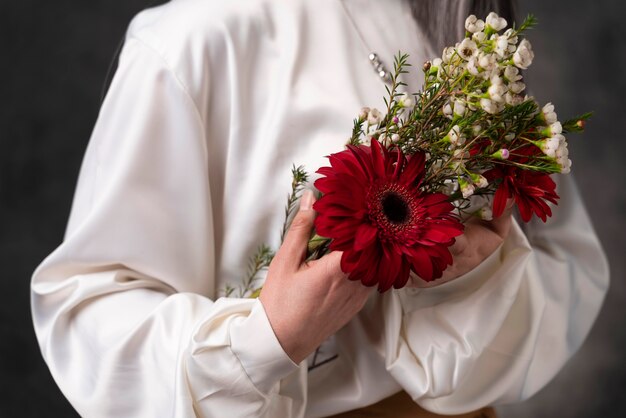 Belo retrato de mulher sênior com flores de perto