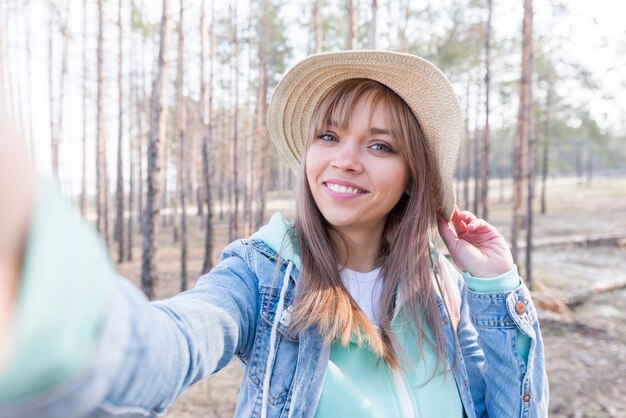 Belo retrato de um viajante feminino tendo auto-retrato na floresta