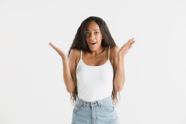 Belo retrato feminino com metade do comprimento isolado no fundo branco do estúdio. Jovem emocional afro-americana com cabelo comprido. Expressão facial, conceito de emoções humanas. Atônito, animado.