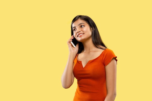 Belo retrato feminino de meio corpo em estúdio amarelo