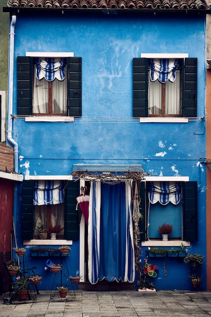 Foto grátis belo tiro simétrico vertical de um edifício suburbano azul com plantas em vasos