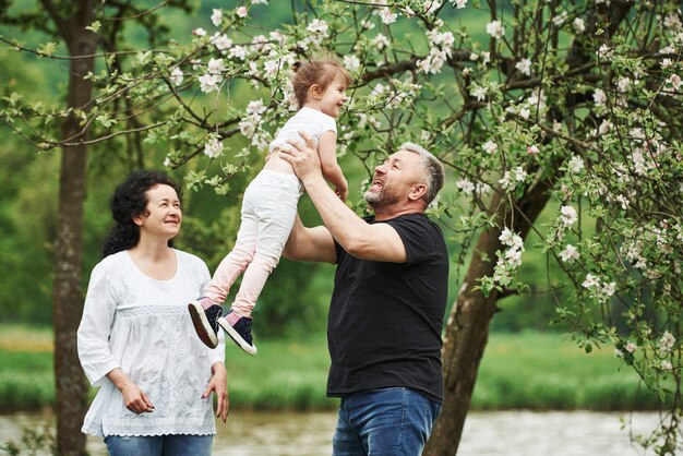 Bem no ar. Casal alegre, aproveitando o bom fim de semana ao ar livre com a neta. Bom clima de primavera