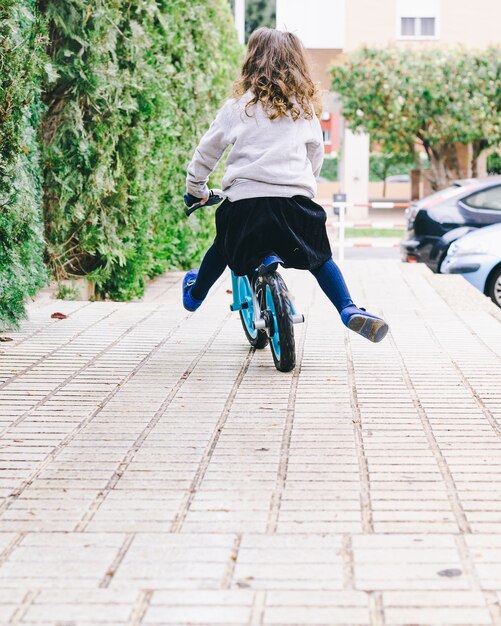 Bicicleta de equitação menina sem rosto