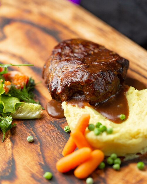 Bife com molho teriyaki com purê de batata, cenoura e feijão verde.