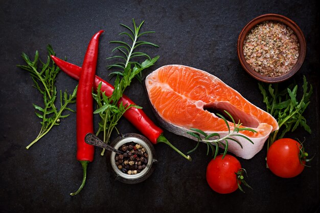 Bife cru salmão e legumes para cozinhar em uma mesa preta. Vista do topo