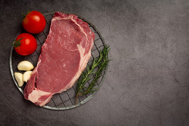 Bife de carne crua fresca na superfície escura.