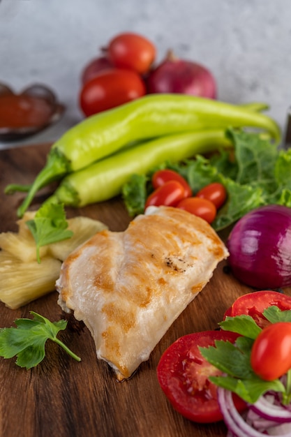 Foto grátis bife de frango colocado em uma bandeja de madeira.