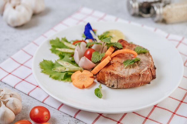 Bife de porco com tomate, cenoura, cebola roxa, hortelã-pimenta, flor de ervilha borboleta e limão.