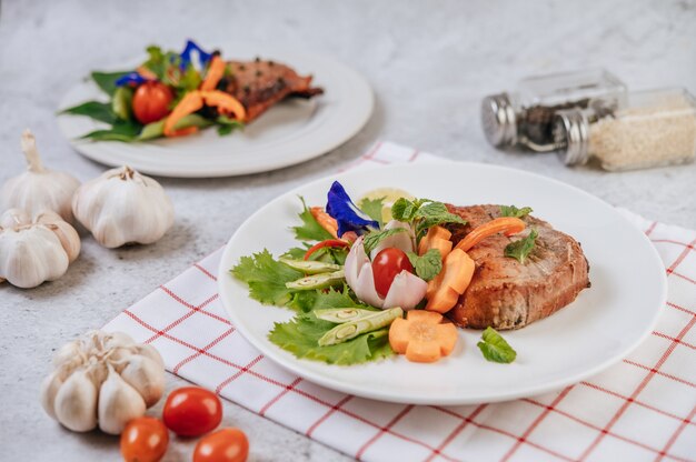 Bife de porco com tomate, cenoura, cebola roxa, hortelã-pimenta, flor de ervilha borboleta e limão.