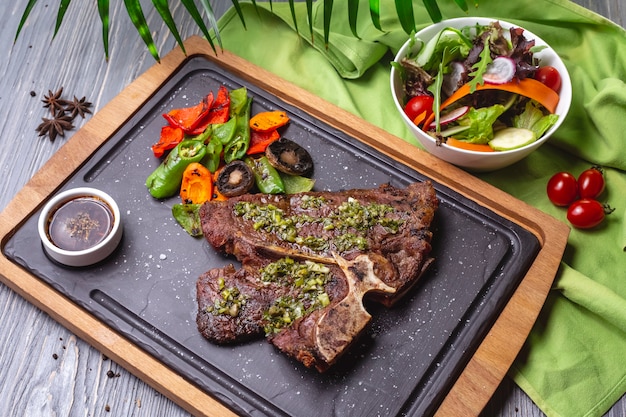 Foto grátis bife de vista superior com legumes grelhados e molho