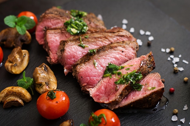 Bife suculento médio raro com especiarias e legumes grelhados.