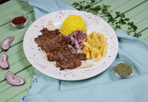 Bifes de carne com batatas fritas e guarnição de arroz