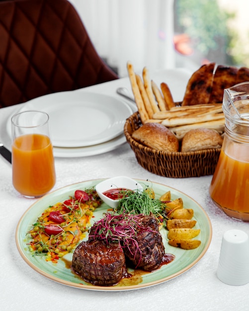 Bifes grelhados com molho de tomate, servido com batata, ketchup e salada