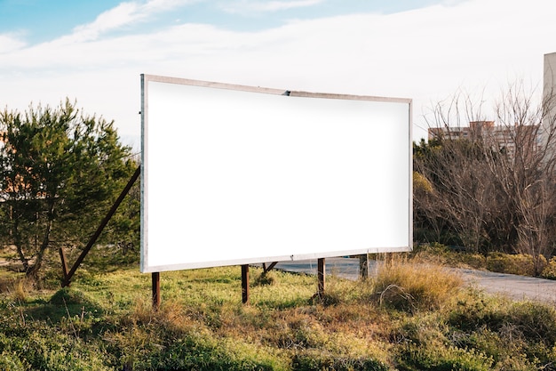 Big white billboard on green roadside