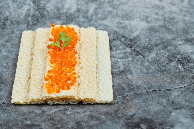 Biscoito com caviar vermelho.